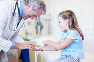 A cute little girl receiving a checkup from her doctor